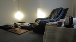 Image displays a spa atmosphere with a black reclined chair and dim lighting.