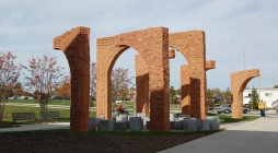 Image displays large arches that have each half detached and placed so the arches appear at certain angles that are located in front of the PAHB