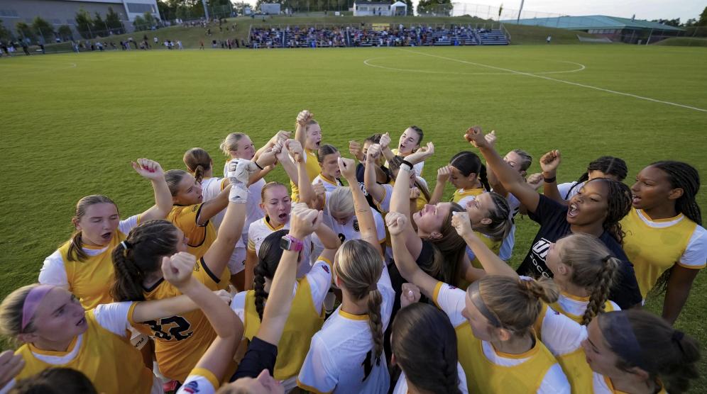 Photo of UMBC women's soccer team huddled up on the field